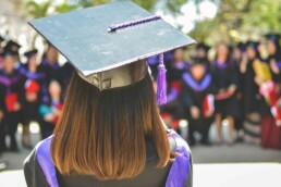 woman wearing higher education graduation cap and robe