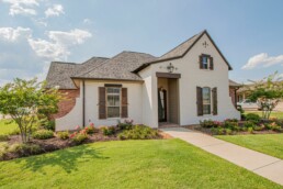 A white and brown home with a lawn, a great hedge against inflation