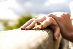 A well-manicured hand holding a gold wedding ring, symbolizing Divorce and how Breakups affect your credit