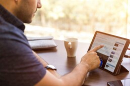 A man using a tablet, looking for open-source tools to use.